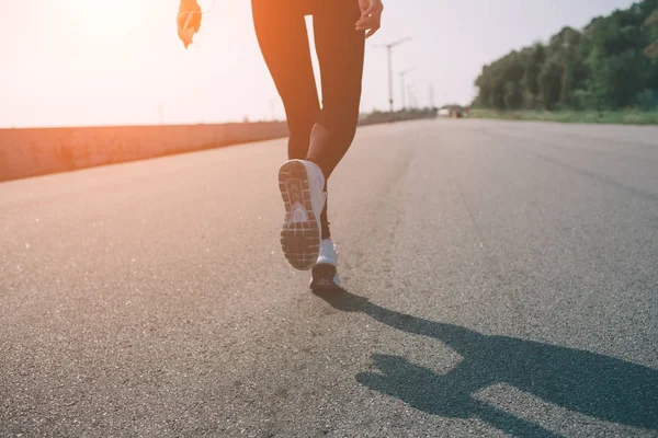 Günbatımı sırasında çalışan güzel bir kadın. Genç fitness modeli sahil yakınında. Giymiş spor giyim.