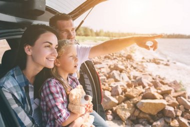 Mutlu aile arabalarında bir yolculuğa. Baba, anne ve kızı deniz ya da okyanus veya nehir seyahat. Yaz sürmek otomobil yanında