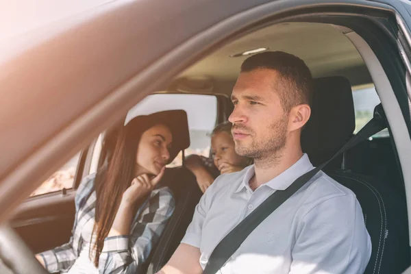 Familia feliz en un viaje por carretera en su coche. Papá, mamá e hija están viajando por el mar o el océano o el río. Paseo de verano en automóvil — Foto de Stock