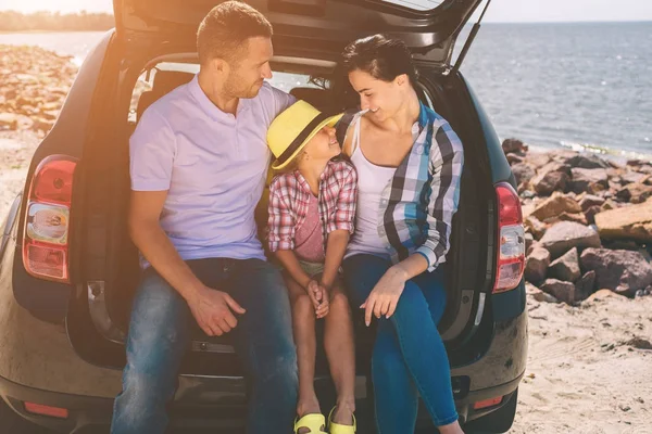 Glückliche Familie auf einer Autoreise. Papa, Mutter und Tochter sind am Meer oder auf dem Meer oder Fluss unterwegs. Sommerfahrt mit dem Auto — Stockfoto