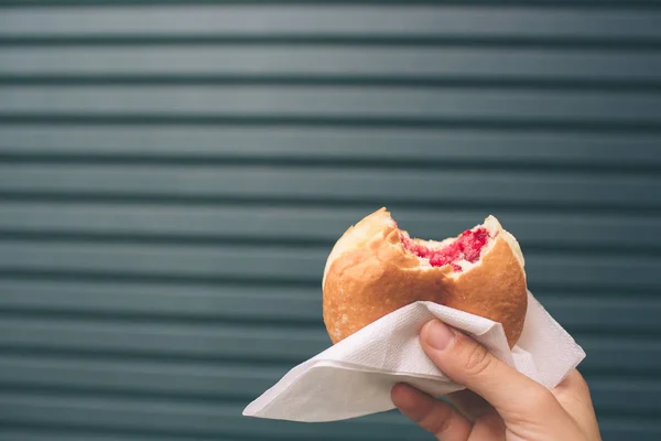 Weibliche Hand ohne Maniküre, die einen Donut hält — Stockfoto