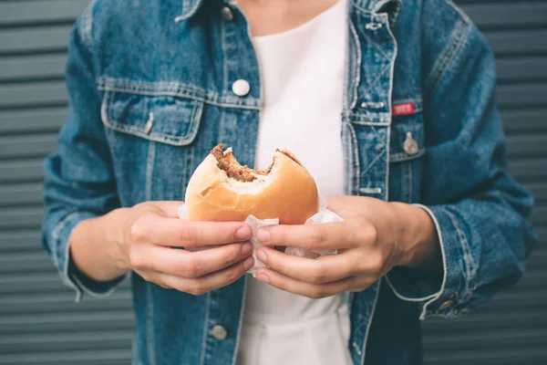 Comiendo hamburguesas. Deliciosa hamburguesa en las manos. Comida rápida . — Foto de Stock