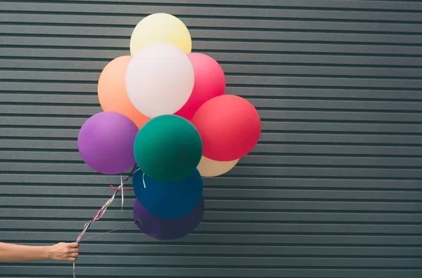 Mångfärgade, latex ballonger fyllda med helium nära den grå väggen. , festligt koncept med plats för din text — Stockfoto
