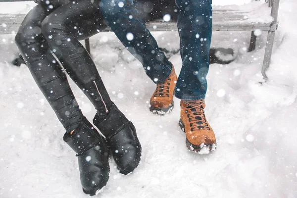 Glada unga par i vinter. Familjen utomhus. man och kvinna titta uppåt och skrattar. Kärlek, roligt, säsong och människor - som vandrar i Vinterparken. En ovanifrån, vinterstövlar. — Stockfoto