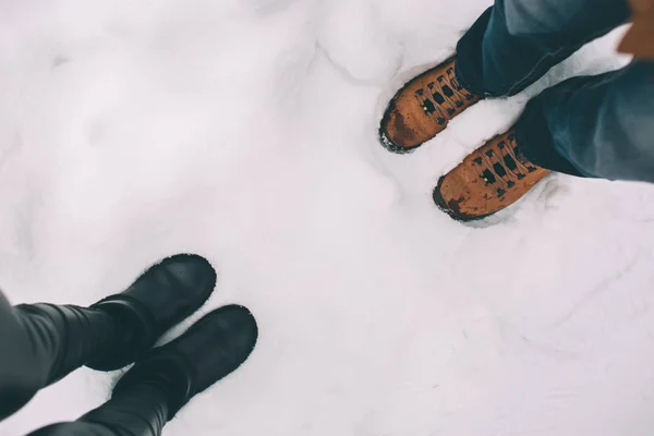 快乐的年轻夫妇在冬天。家庭户外。男人和女人看向上和笑。爱, 乐趣, 季节和人-漫步在冬天公园。互相对立, 顶部视图, 冬靴. — 图库照片