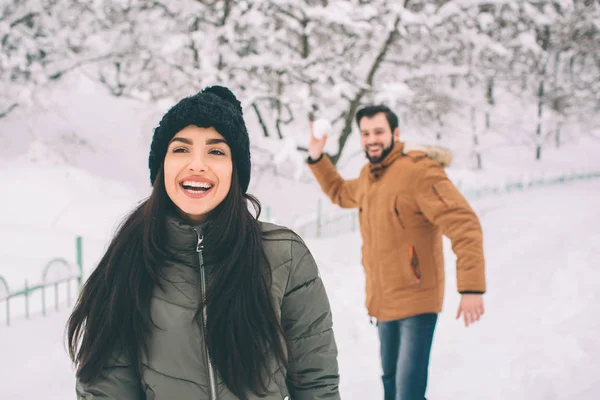 Glückliches junges Paar im Winter. Familie im Freien. Mann und Frau blicken nach oben und lachen. Liebe, Spaß, Jahreszeit und Menschen - Wandern im Winterpark. er schneit — Stockfoto