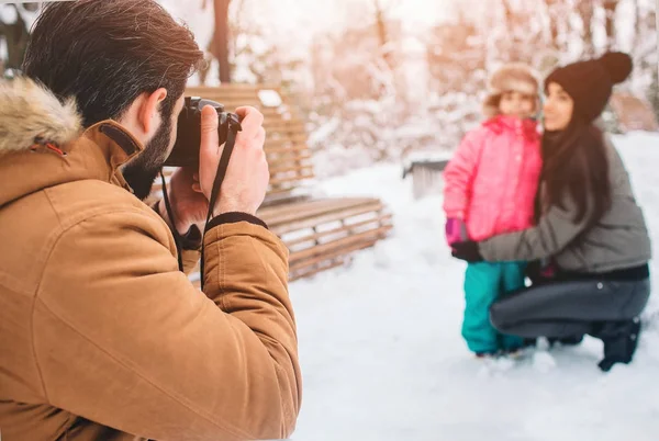 Kindererziehung, Mode, Jahreszeit und Menschen-Konzept - glückliche Familie mit Kind in Winterkleidung im Freien. Fotografieren Sie miteinander — Stockfoto