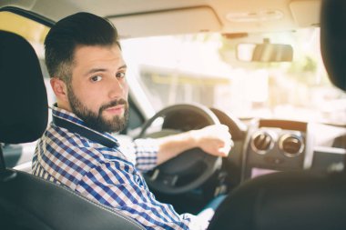 Zarif ciddi yakışıklı bir araba kullanıyor.