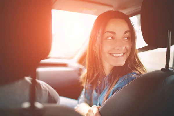 Vacker kvinna leende medan du sitter på de främre passagerarsätena i bilen — Stockfoto
