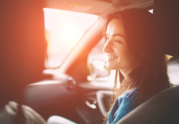 Belle femme souriante assise sur les sièges passagers avant dans la voiture — Photo