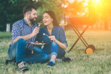 Barbekü yapma ve doğada öğle yemeği arkadaşlar. Piknik - barbekü partisinde mutlu insanlar, içme ve yemek yeme sırasında eğlenmek Çift.