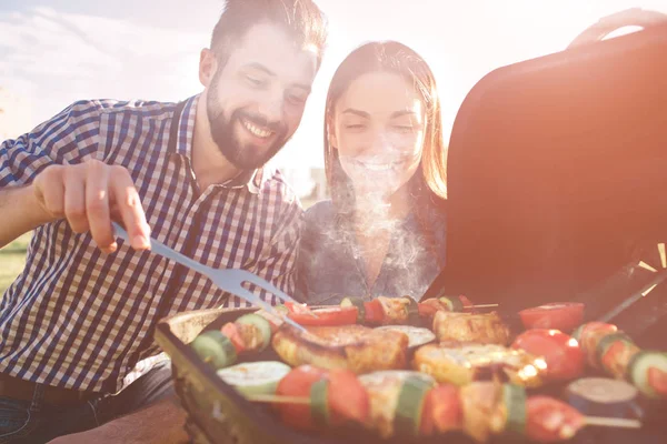 Barbekü yapma ve doğada öğle yemeği arkadaşlar. Piknik - barbekü partisinde mutlu insanlar, içme ve yemek yeme sırasında eğlenmek Çift.