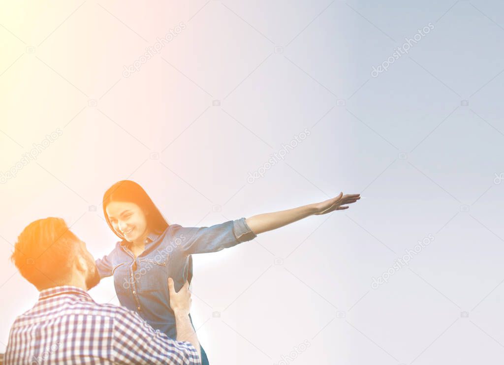 holidays, vacation, love and friendship concept - smiling couple having fun over sky background.