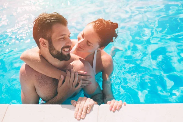 Veselý mladý chlap a paní odpočívá a venkovní bazén. Pár ve vodě. Kluci v létě sephi — Stock fotografie