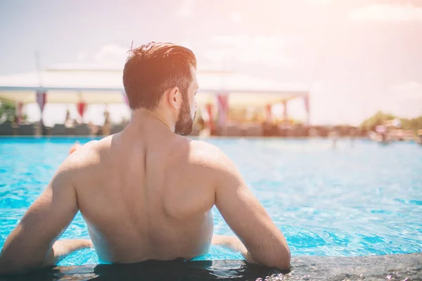 Foto de verano del hombre musculoso sonriente en la piscina. Feliz modelo masculino en el agua en las vacaciones de verano . — Foto de Stock