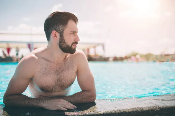 在游泳池的肌肉微笑的人的夏天相片。愉快的男性模型在水在夏天假期. — 图库照片