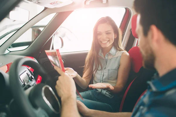 Bella giovane coppia in piedi presso la concessionaria scegliendo l'auto da acquistare — Foto Stock