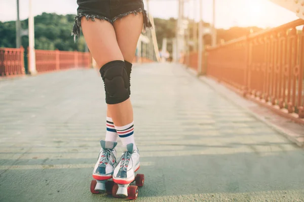 Mulheres jovens magras e sensuais e patins. Férias ativas de verão na cidade. Esportes radicais — Fotografia de Stock