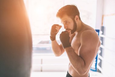 Yakışıklı sakallı boksör çıplak gövde ile yumruklar dövüş kulübü, pratik