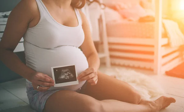 Ciężarna para z USG. Pojęcie opieki zdrowotnej nad ciążą — Zdjęcie stockowe