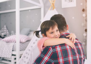 Şirin küçük kızı ve yakışıklı genç babası çocuk odasında birlikte oynuyorlar. Baba ve çocuk, yatak odasında yerde otururken birlikte vakit geçiriyorlar..