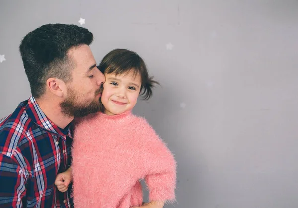 Roztomilá dcerka a její hezký mladý táta si spolu hrají v dětském pokoji. Táta a dítě spolu tráví čas, zatímco sedí na podlaze v ložnici. — Stock fotografie