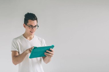 İnek gözlüklü beyaz boş ekran tablet cihaz tutar. Beyaz bir arka plan üzerinde duran bir adam bir beyaz T-shirt