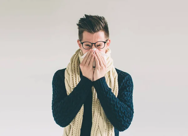 Photo de studio d'un jeune homme avec mouchoir. Le malade isolé a le nez qui coule. homme fait un remède pour le rhume commun.Nerd porte des lunettes — Photo