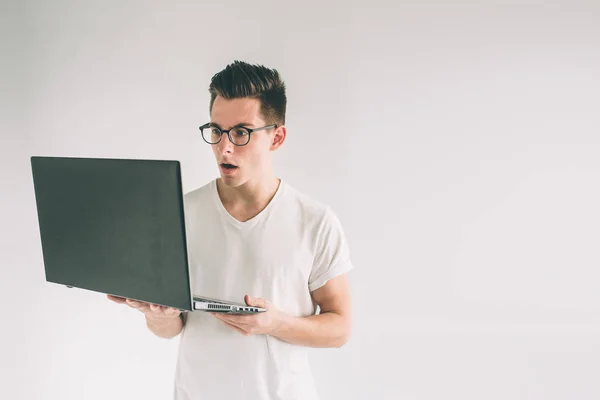 Man holding laptop computer isolated on gray. Nerd is wearing glasses. — Stock Photo, Image