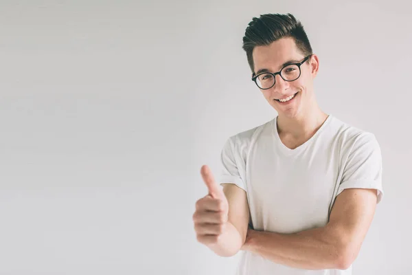 Man with thumbs up - isolated over light background. Nerd is wearing glasses. — Stock Photo, Image