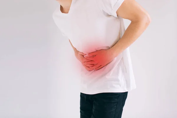 Joven que tiene un dolor de estómago.. Primer plano del cuerpo masculino aislado sobre fondo blanco — Foto de Stock