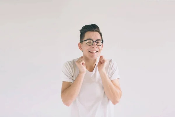 Mann in weißem T-Shirt und Brille mit breitem Lächeln auf weißem Hintergrund. ein sehr netter Student hat gute Laune — Stockfoto