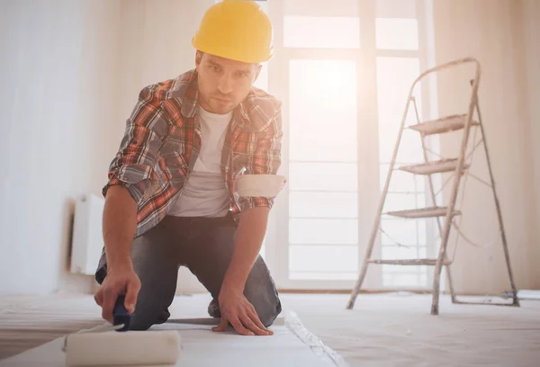 Arbeiter beim Tapezieren. Der Bauarbeiter klebt die Tapete an — Stockfoto