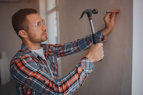 Der Bauarbeiter arbeitet auf der Baustelle. Arbeiter mit Eimer und Farbeimer nahe der Wand. — Stockfoto