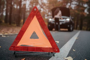 Otomatik yardım ve sigorta, kavram seyahat ederken sorun. Kırık araba ve otomatik üçgen yolda, kadın yardım bekliyor