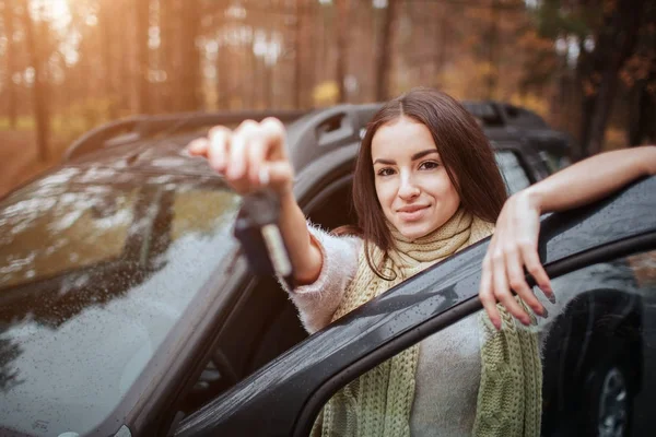 Kobieta trzyma kluczyki do samochodu. Zbliżenie dłoni. Kobieta trzyma kluczyki do samochodu. Zbliżenie dłoni. Koncepcja jesień. Jesień las podróż samochodem. — Zdjęcie stockowe