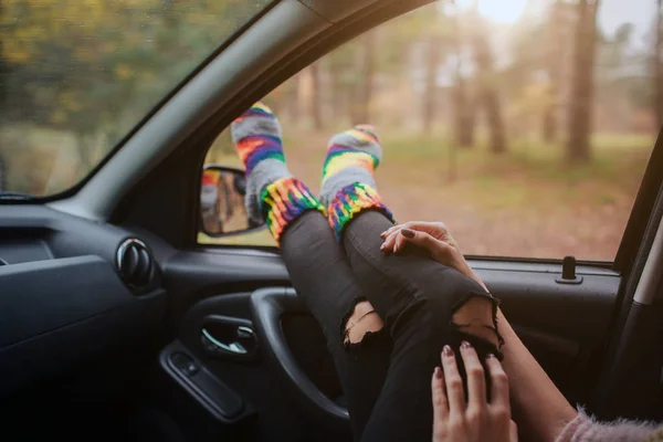 Осень, авто путешествия. Бросание женщины во время дорожного путешествия в машине. Женские ноги в теплых носках на автомобильной приборной панели . — стоковое фото