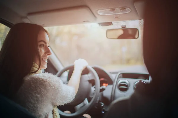 Langhaarige Brünette auf dem Auto-Hintergrund. Ein weibliches Model trägt einen Pullover und einen Schal. Herbstkonzept. Herbstliche Waldfahrt mit dem Auto. — Stockfoto