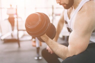 Spor salonunda egzersiz sırasında kas sakallı adam. Atlet kaslı vücut geliştirmeci spor eğitim pazı dumbbell ile içinde. Kapalı fitness