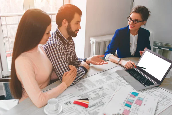 Jeune couple familial achat loyer immobilier. Agent qui donne des conseils à l'homme et à la femme. Signature d'un contrat pour l'achat d'une maison ou d'un appartement ou d'appartements. Écran d'ordinateur portable vide . — Photo