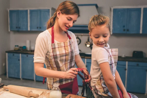 Μαγείρεμα σπιτικό κέικ. Ευτυχισμένη αγάπη οικογένεια ετοιμάζονται αρτοποιείο μαζί. Κοπέλα Κόρη μητέρα και το παιδί είναι το μαγείρεμα μπισκότα και τη διασκέδαση στην κουζίνα. Ποδιές φόρεμα — Φωτογραφία Αρχείου
