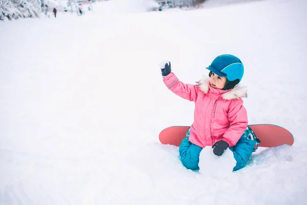 Snowboard Kış Sporu. Küçük kız, kalın kışlık giysiler içinde karla oynuyor. Kış arkaplanı — Stok fotoğraf