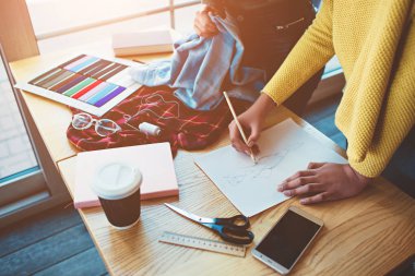 Birlikte ayakta ve aynı moda proje için çalışan iki genç kadın. Onlar giyim bir parça kesti ve onlar gelecek giyim koleksiyonu hakkında bazı fikirler var yeni bir şey yaratmak için çalışıyoruz.