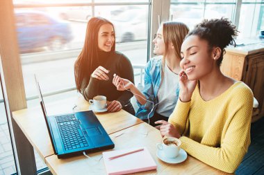 Ağaç genç kadın birlikte büyük pencereler küçük bir kafede oturan ve birbirleri ile konuşuyor. Onlardan biri müzik dinleme ve çok mutlu ve iki sadece onların konuşma zevk