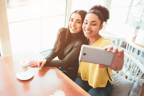 Esta es una selfie de dos hermosas chicas que se ven tan increíbles y felices al mismo tiempo. Están en la cafetería bebiendo un poco de café final disfrutando de pasar tiempo juntos. De cerca. Vista de corte . — Foto de Stock