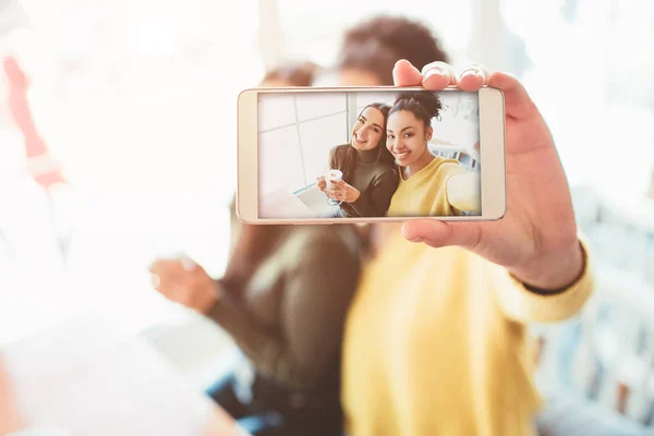 Dies ist ein Selfie von zwei wunderschönen Mädchen, die so toll und glücklich zugleich aussehen. Sie sitzen im Café und trinken einen Kaffee und genießen die gemeinsame Zeit. Nahaufnahme. Schnitt-Ansicht. — Stockfoto