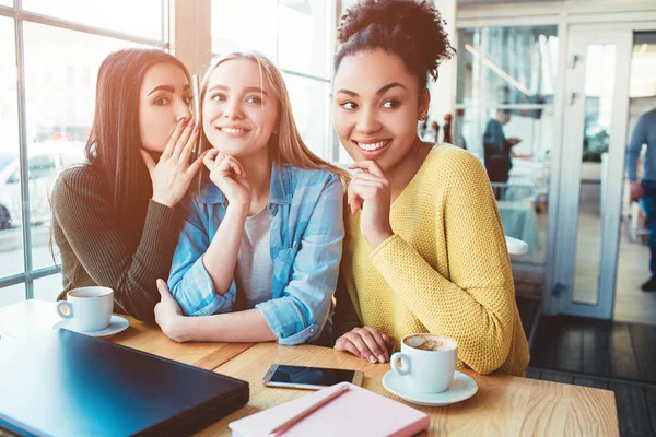 Otra foto de tres chicas chismeando sobre algo. Uno de ellos está tratando de decir lo que está pensando sobre la terrible situación mientras los otros dos sonríen y miran a un lado — Foto de Stock