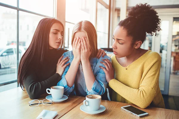 Een foto van beste vrienden niet in een goed humeur. Een van hen is huilen en de andere twee niet weet wat te doen en hoe kunnen ze helpen haar om te stoppen met huilen — Stockfoto