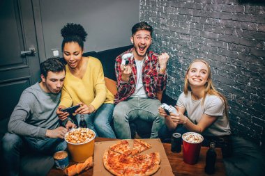 Küçük bir grup öğrenci oturma odasında. İki tane birden adam savaşı kazandı ve bu konuda çok mutlu oyun oynuyorduk. Diğer iki whatching film telefonda vardır.