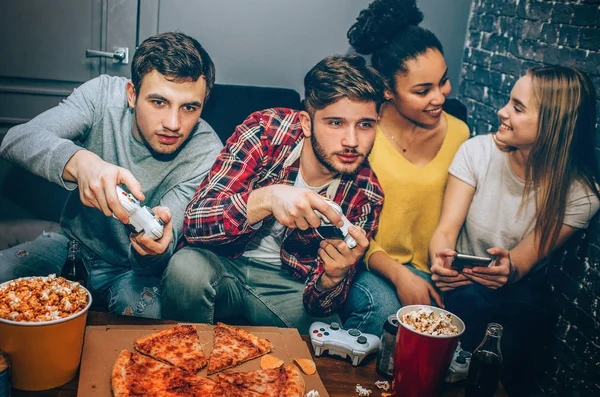 Närbild av intensiva spel mellan två pojkar. De konkurrerar sinsemellan. Ingen vill förlora. I det ögonblicket flickor sitter nära varandra och talar. — Stockfoto